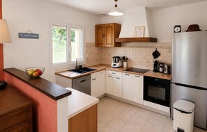 Eine moderne Küche mit Geschirrspüler, Backofen und Kühlschrank.