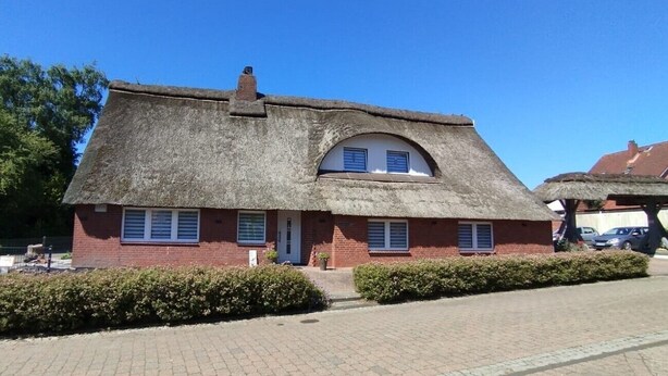 A thatched-roof building with a brick facade, a small porch, and a paved driveway. - Relax under thatch with pool, beach chairs and loungers (Belum)