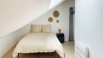 Une chambre à coucher avec un lit, une table de chevet et un radiateur.
