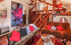 Ein gemütliches Wohnzimmer mit einer Couch, einem Couchtisch und einer Treppe.