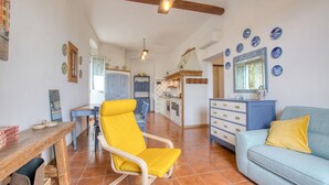 Un vaste espace de vie comprenant une table à manger, un fauteuil jaune et un canapé.