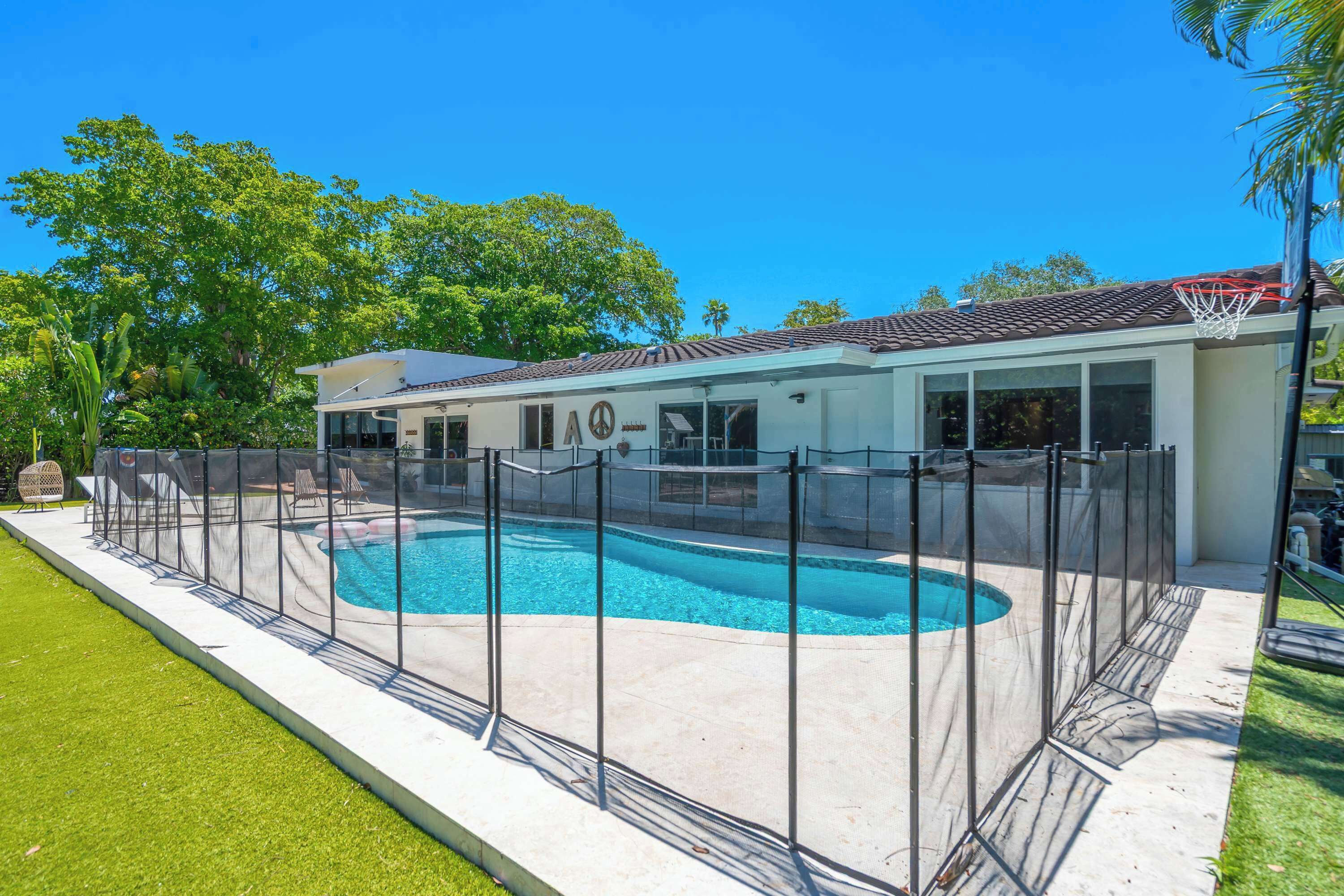 The back yard oasis boasts a private pool, putting green, lounge space, & more!​
