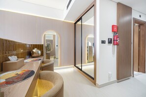 Ein modernes Badezimmer mit einem großen Spiegel, einem Handtuchhalter und einem an der Wand montierten Feuerlöscher.