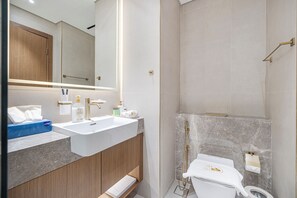 Ein modernes Badezimmer mit einem großen Spiegel, zwei Waschbecken, einer Toilette und einer Duschkabine.