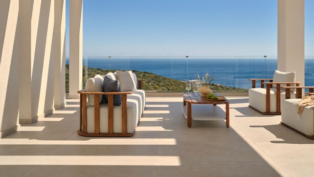 Un área de estar moderna al aire libre con vista al mar.