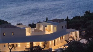 Una casa moderna con terraza vista al mar, piscina y jardín.