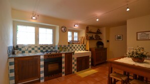 Uma cozinha com fogão, forno, pia e um espaço de jantar com mesa e cadeiras.