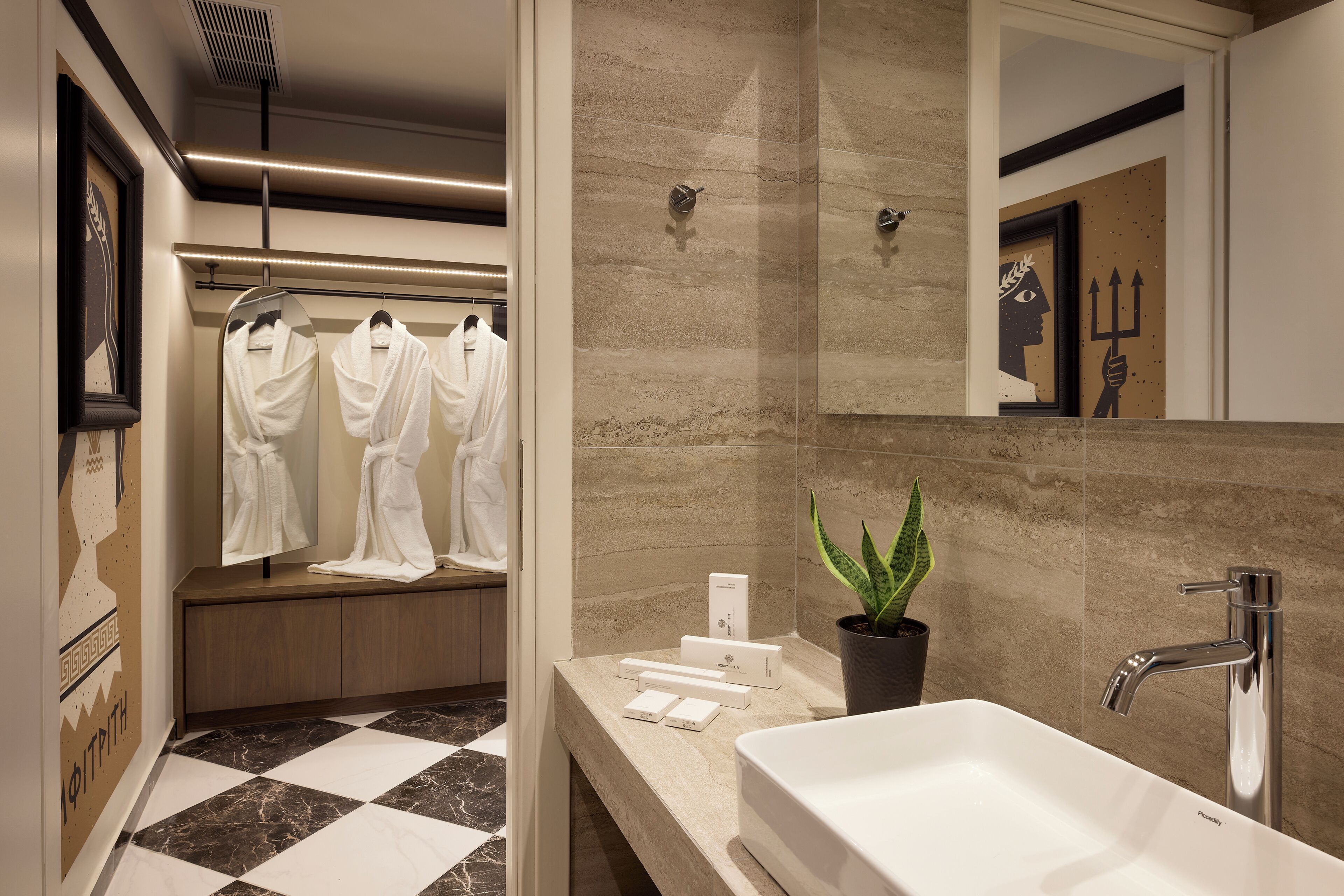 A modern bathroom with a checkered floor, a white sink, a mirror, and a potted plant.