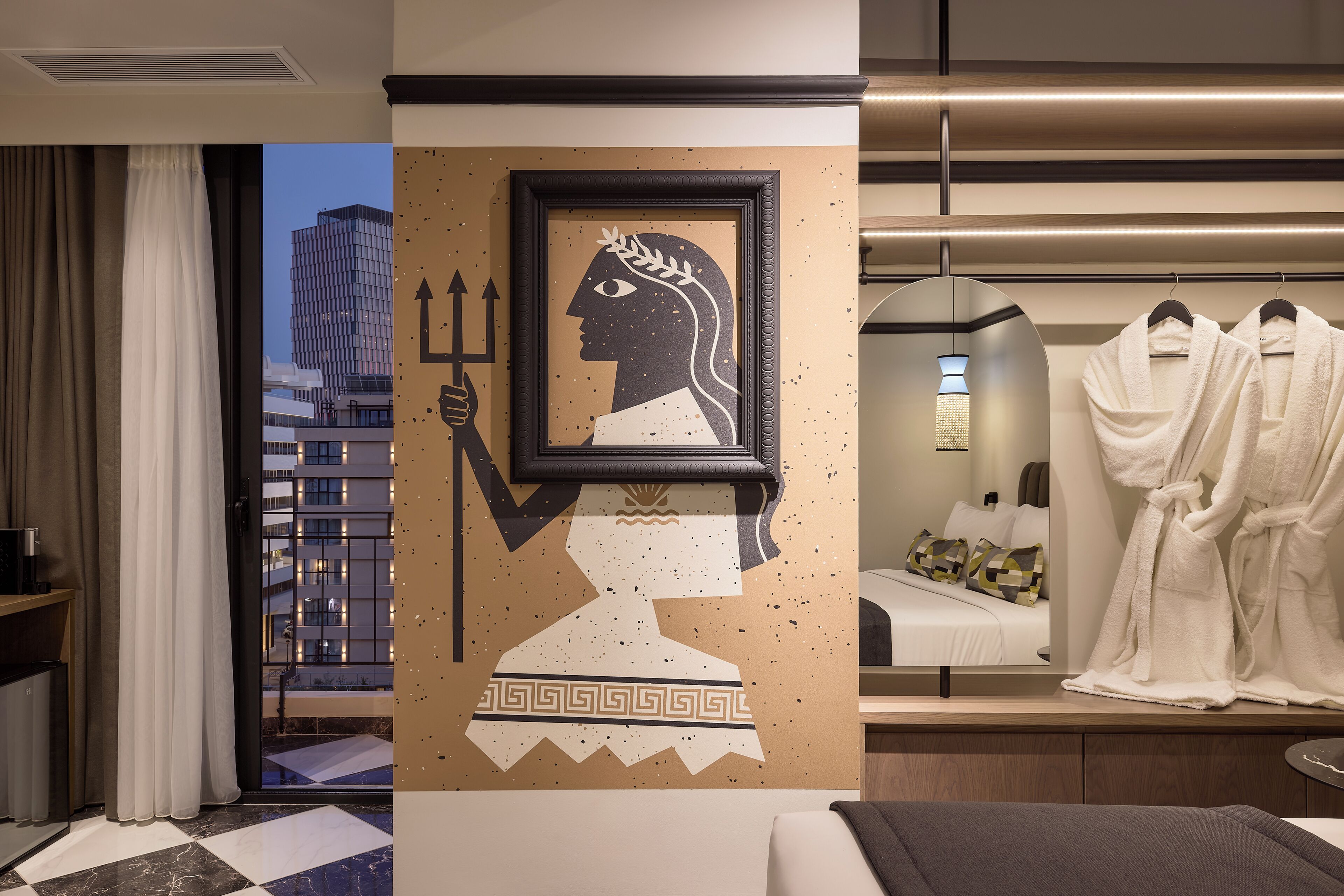 A hotel room with a large window, a framed artwork, a bed with pillows, and a robe rack.