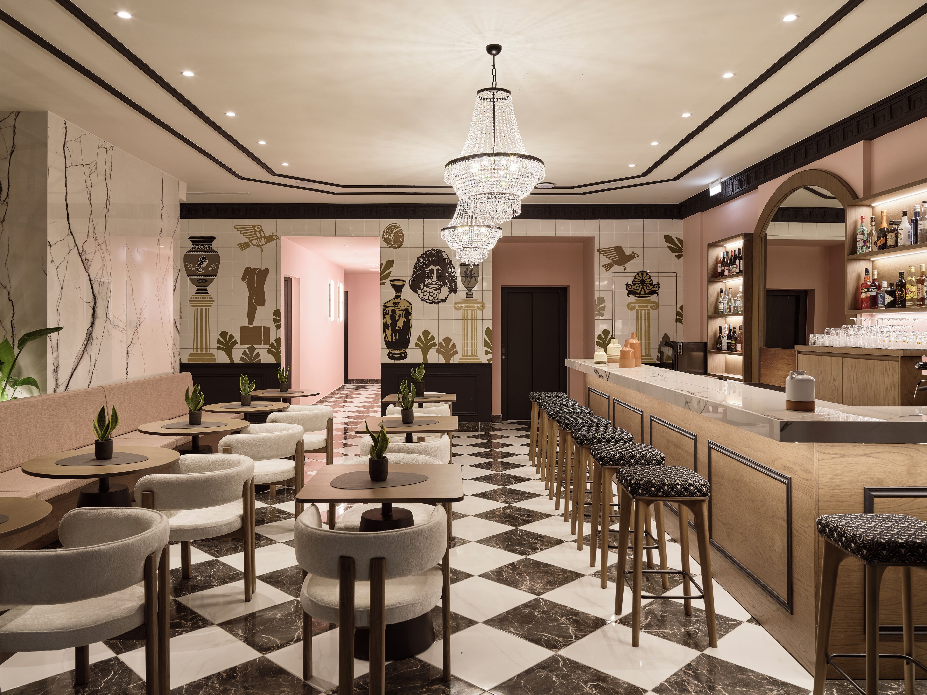 A bar area with a checkered floor, bar stools, a bar counter, and a chandelier.