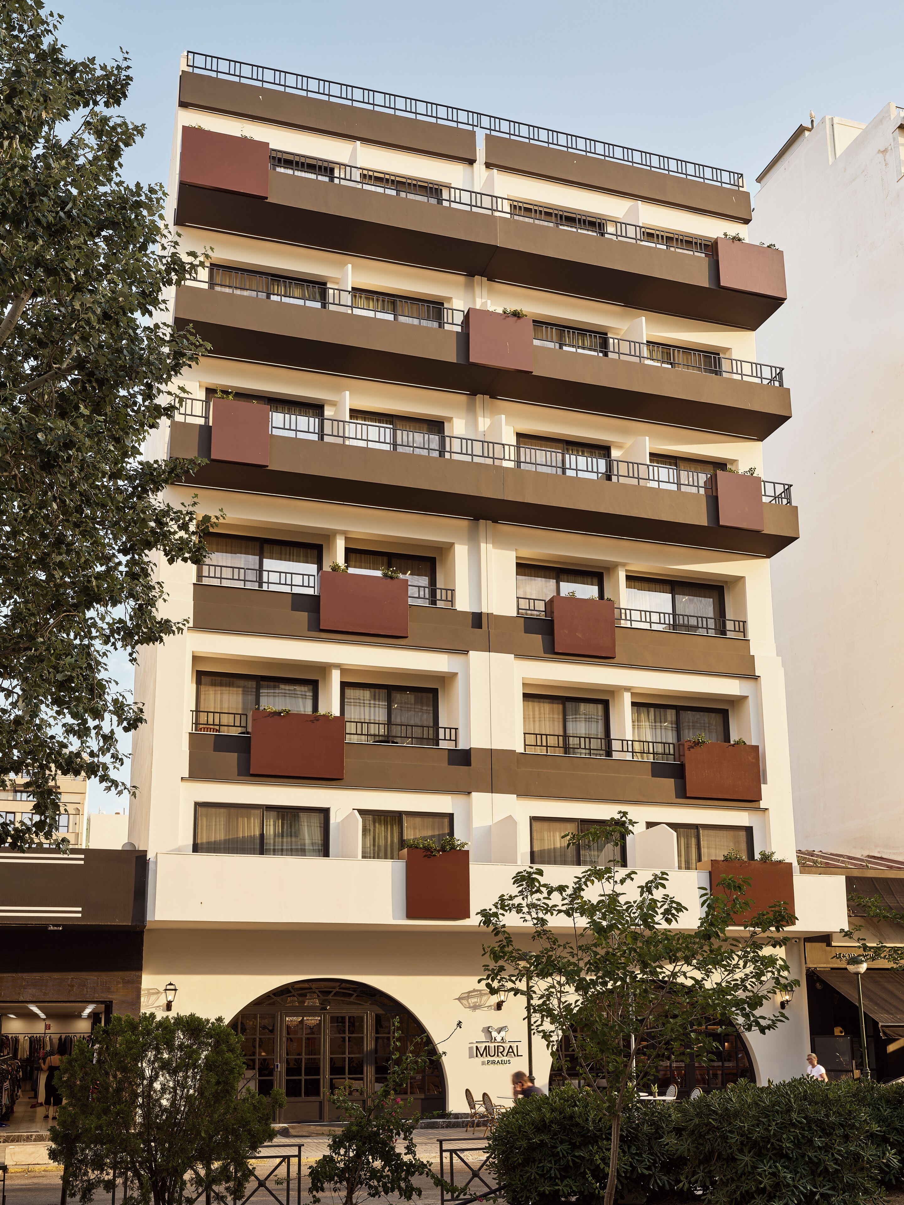 A multi-story building with balconies, a storefront, and a sign for 'MURAL'.