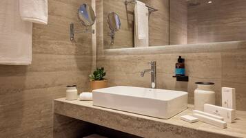 A modern bathroom with a large mirror, two towel racks, a sink, and a shower area.