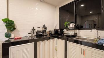 A modern kitchen with white cabinets, a black countertop, and a large window.