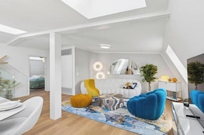 A modern interior with a loft-style ceiling, a seating area with a sofa and ottoman, a dining table, and a small side table with decorative items. - IKON Old Town Penthouse | AC, Lake & Mountain View (Zürich)