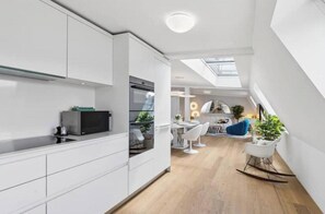 A modern kitchen with white cabinetry and a skylight. - IKON Old Town Penthouse | AC, Lake & Mountain View (Zürich)