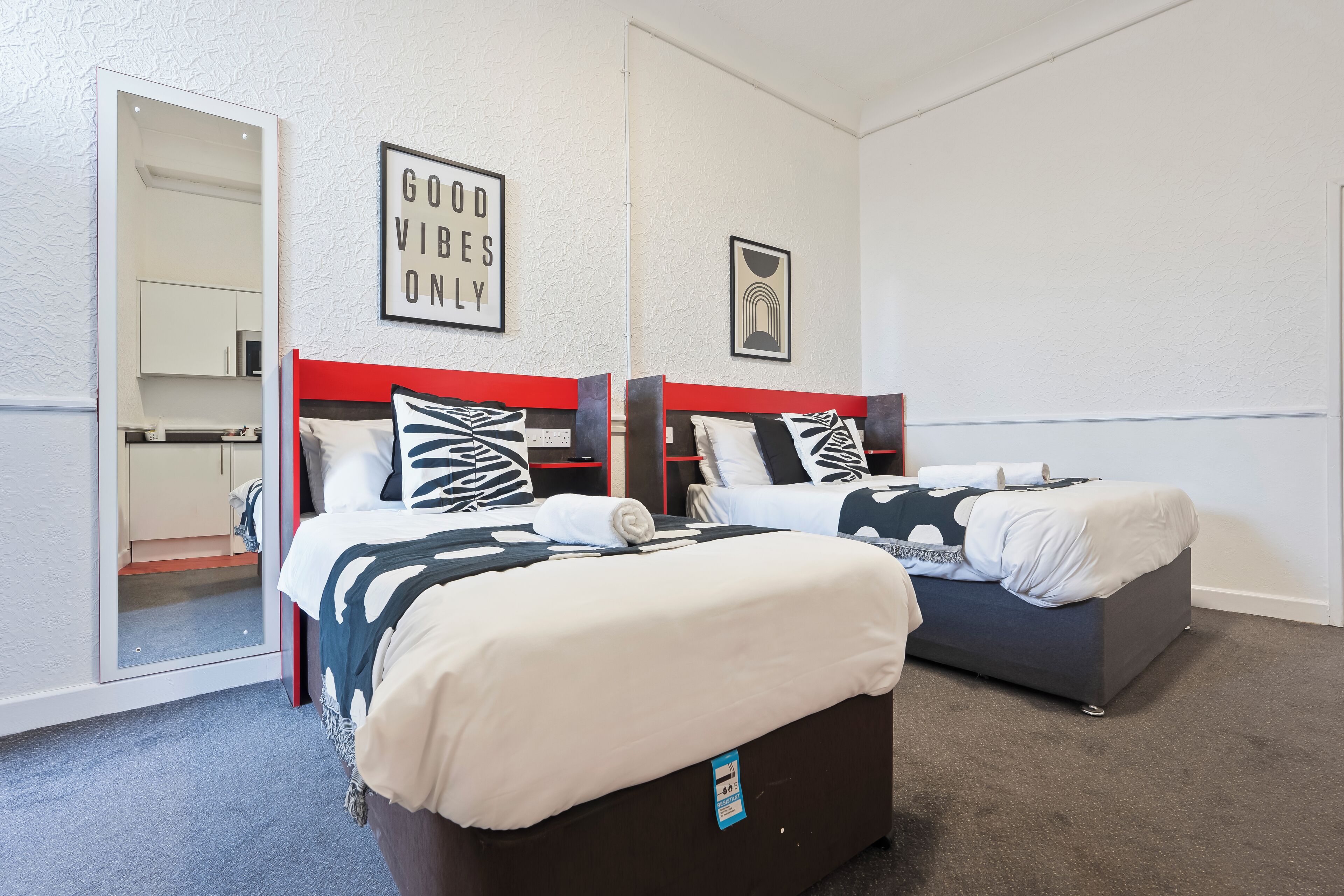 Ein Hotelzimmer mit zwei Betten, einem Kleiderschrank und einem Spiegel.