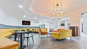 A modern interior with seating arrangements, a television screen, and a decorative archway. - Compact Studios in Dudley (Dudley)