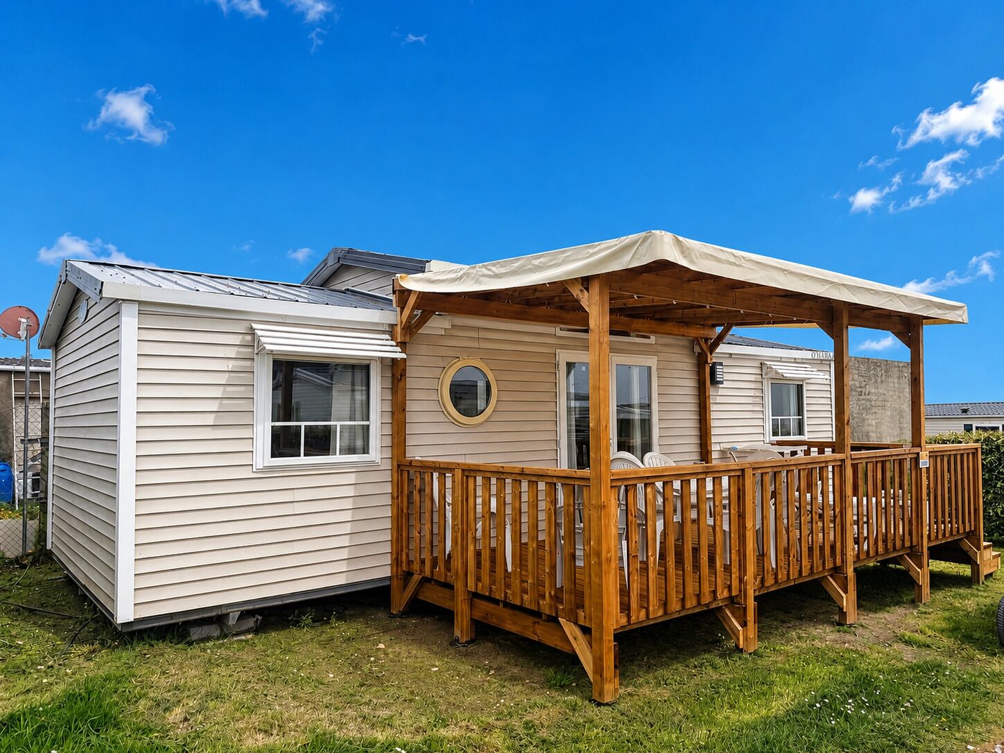 Une maison mobile dotée d’une terrasse en bois et d’un porche abrité.
