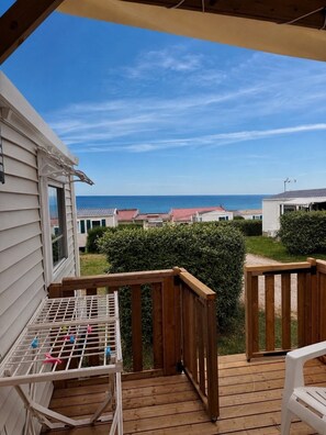 A wooden deck with a view of the ocean and other buildings. - Mobile home CONFORT le Portel plage chez Nono et Alex (Le Portel)