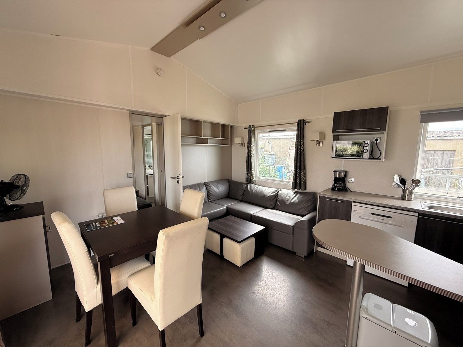 A compact kitchenette with a dining area, a sofa, and a small table.