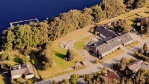 An aerial view of a residential area with houses, a road, and a body of water.