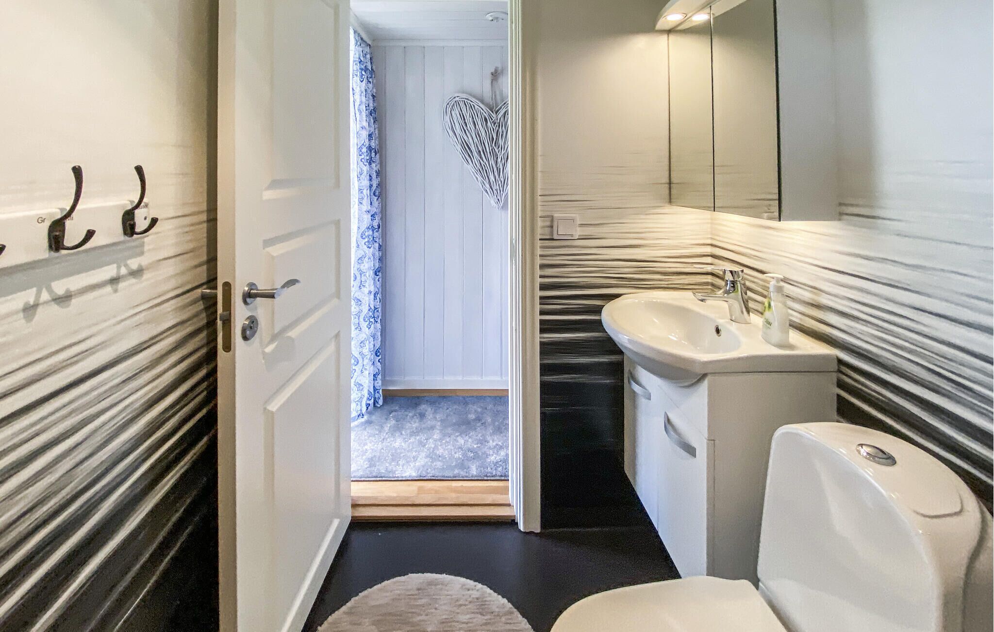 Ein Badezimmer mit Waschbecken, Spiegel und Toilette.