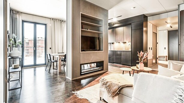 A modern living room with a fireplace, a dining area, and a kitchen. - Cozy home in Järbo with sauna (Järbo)