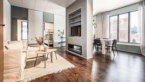 A modern living room with a sofa, coffee table, TV, and dining area. - Cozy home in Järbo with sauna (Järbo)