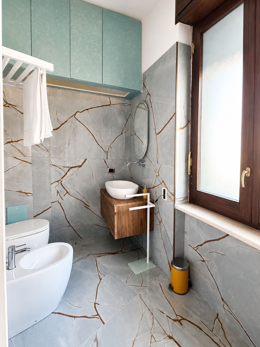 A bathroom with a white bathtub, a wooden vanity, and a large mirror.