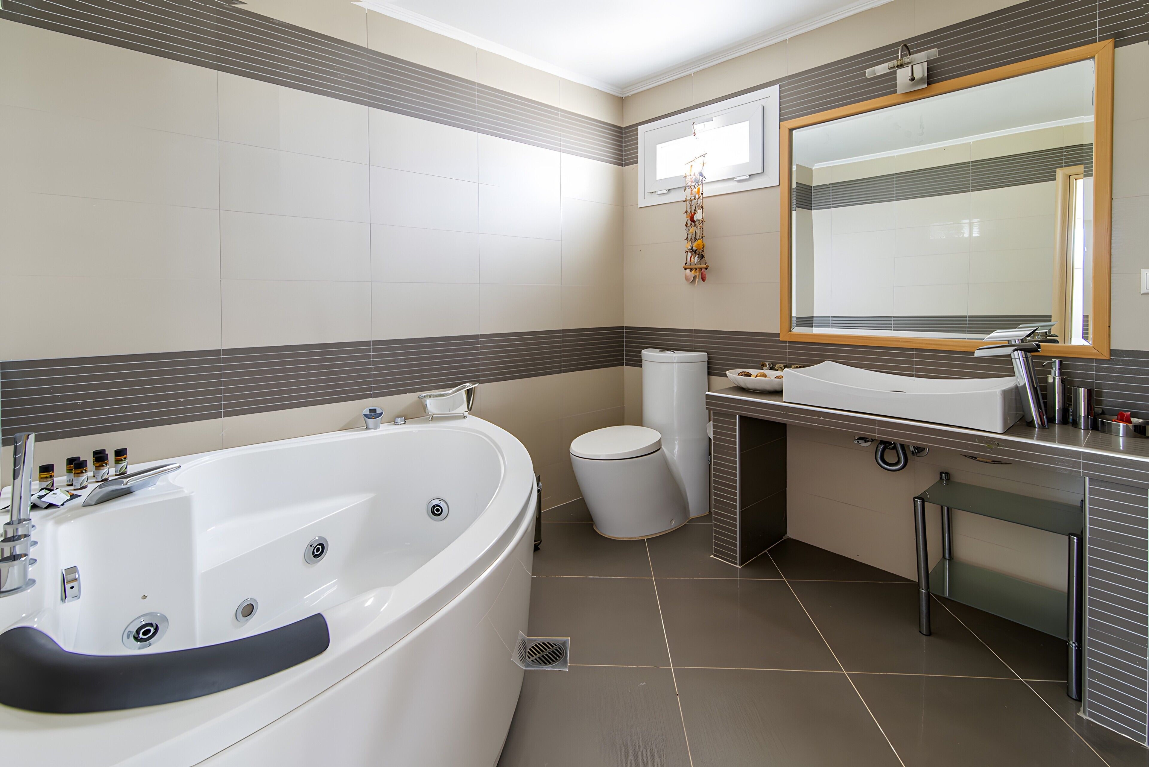Une salle de bain moderne dotée d’une grande baignoire, de toilettes et d’un espace lavabo.