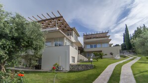 Une maison moderne à deux étages, avec un chemin en pierre menant à l’entrée.