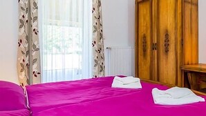 A room with a bed, a wooden wardrobe, and a window with curtains. - 3 bedroom beautiful home in Jasenak (Jasenak)