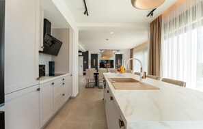 Eine moderne Küche mit einer großen Kochinsel, eingebauten Geräten und einem Essbereich mit Blick.
