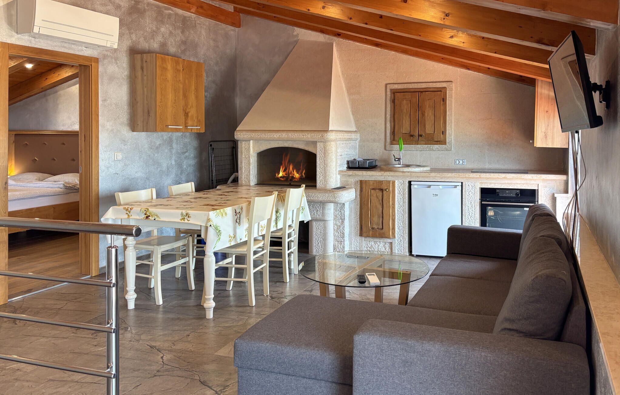 Ein gemütliches Interieur mit Essbereich, Kamin, Küche und einer Couch.