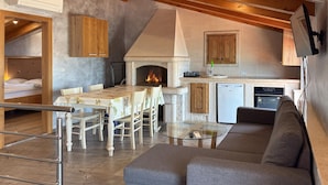 Un interior acogedor con comedor, chimenea, cocina y sofá.