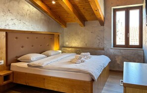 A bedroom with a wooden bed, a headboard, a nightstand, a window with a view, and a wooden ceiling. - Awesome apartment in Umag with WiFi (Umag)