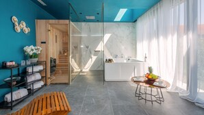 Een moderne badkamer met een douchecabine van glas, een witte wastafel en een marmeren spatwand.