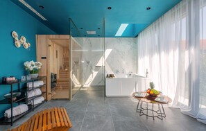 Ein modernes Badezimmer mit Duschkabine aus Glas, einem weißen Waschbecken und einer Marmor-Spritzschutzwand.