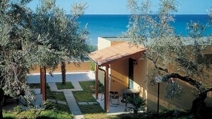 Eine Küstenimmobilie mit Terrasse, Sitzgelegenheit im Freien und Meerblick.