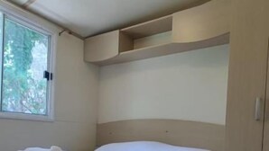 Ein Schlafzimmer mit Bett, Fenster und Deckenleuchte.