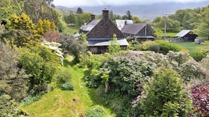 A rural house surrounded by lush greenery and a clear path leading to it. - Y Cwtch (Dolgellau)
