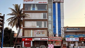 A multi-story building with various businesses including a family restaurant, a bar, and a convention hall. - Hotel Cityleaf (Shimoga)