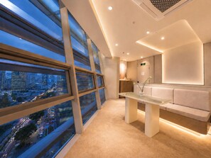 A modern hotel lobby with large windows, a reception desk, and a seating area.