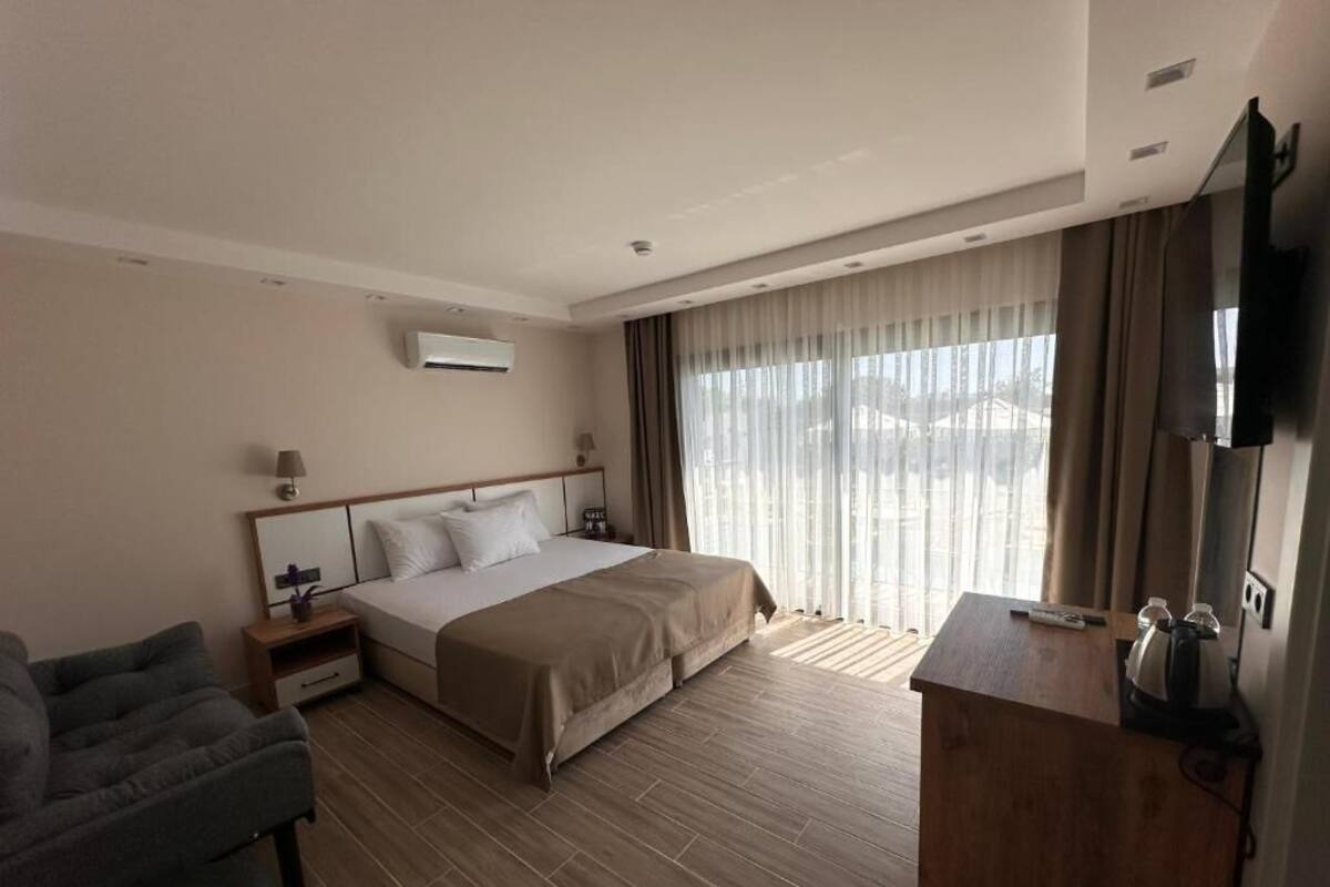 Una habitación de hotel con cama, escritorio, silla y televisor.