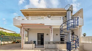 A two-story building with a balcony, a spiral staircase, and a door. - 2 bedroom lovely home in Santa Maria del Focall (Santa Maria del Focall)