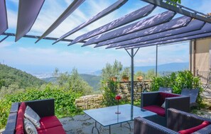 A patio with wicker furniture, a glass table, and a view of a mountainous landscape. - Amazing home in Sesto Fiorentino (Sesto Fiorentino)