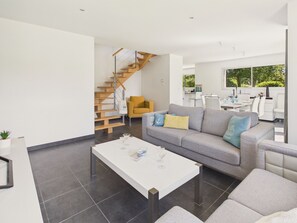 A modern living room with a grey sofa, a white coffee table, and a wooden staircase. - House for 6 in Fouesnant with garden (Fouesnant)