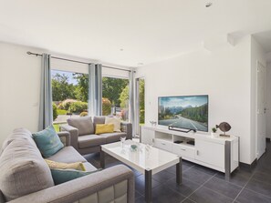 A modern living room with a sofa, coffee table, and a flat-screen TV. - House for 6 in Fouesnant with garden (Fouesnant)