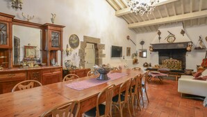 Un ampio soggiorno con camino, mobili in legno e zona pranzo.