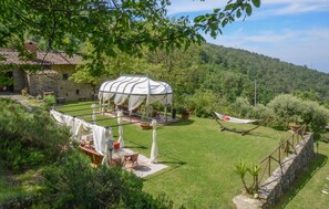 A garden with a gazebo, a hammock, and a stone house. - Awesome home in Sesto Fiorentino with sauna (Sesto Fiorentino)